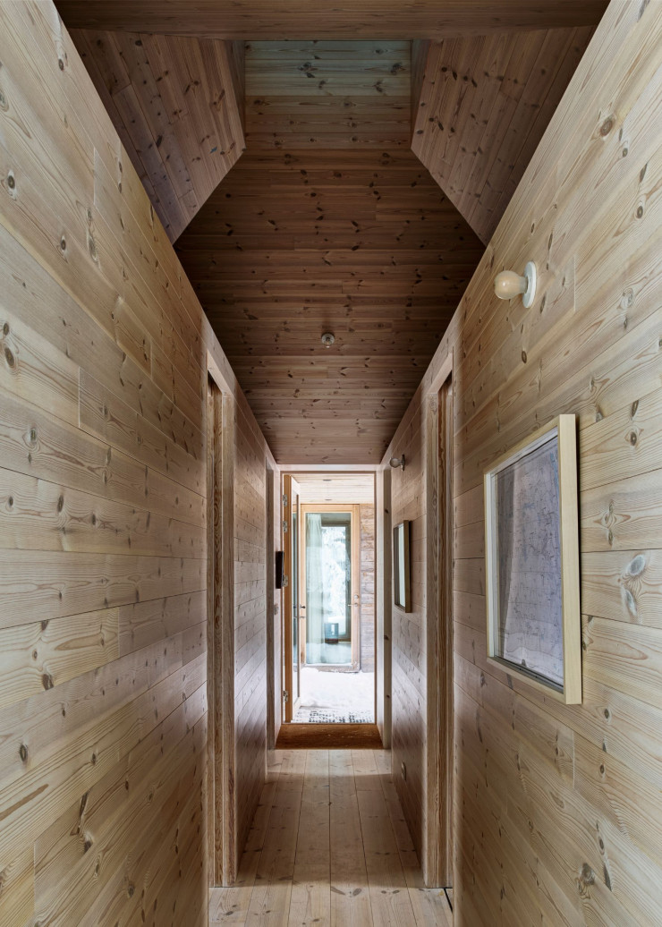 Les pièces sont distribuées le long d’un corridor tout en bois qui diffuse une odeur réconfortante. Comme dans le salon et dans la chambre, le plafond est percé d’un puits de lumière.